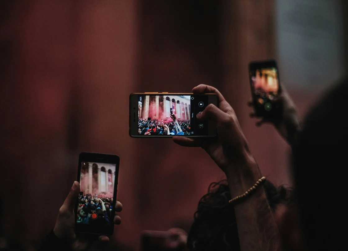 Persone che scattano foto con il cellulare a un evento