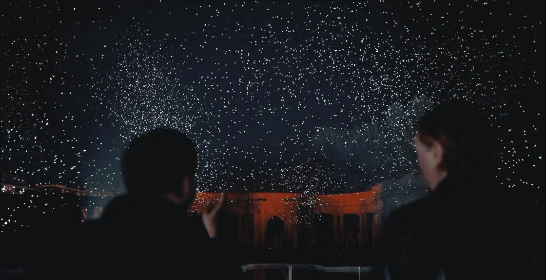 Foto di due ragazzi che guardano il cielo stellato di notte