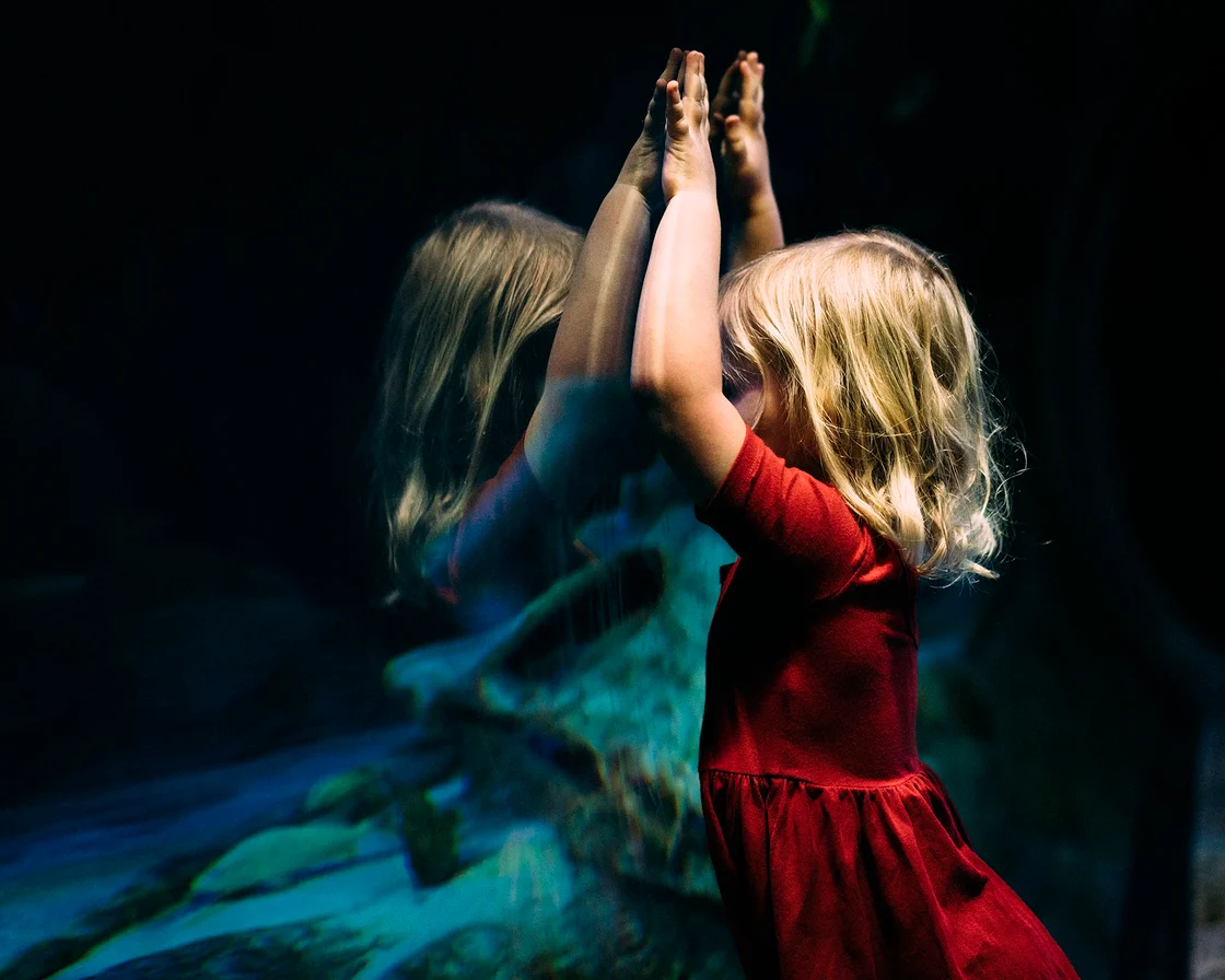 Immagine di una bambina riflessa che guarda se stessa